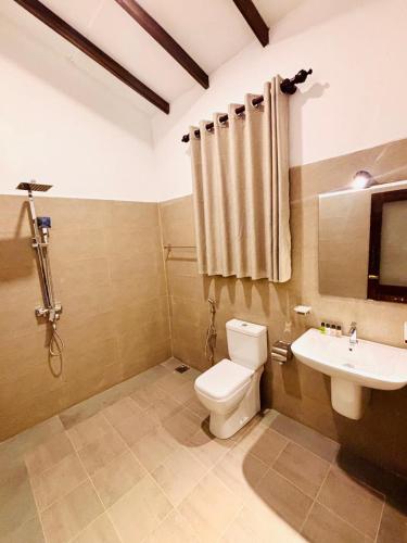 a bathroom with a toilet and a sink at Hotel Siyomin in Ahangama