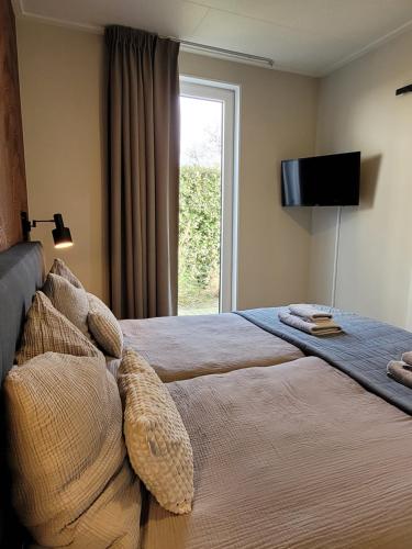 a bedroom with a bed with a television on the wall at Vakantiehuis Huisje 31 Zoutelande in Zoutelande