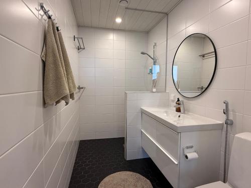 a white bathroom with a sink and a mirror at Willa Koivuranta Kajaani in Pikkuhannus