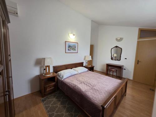 a bedroom with a bed and two lamps and a mirror at House Belavici in Hreljići