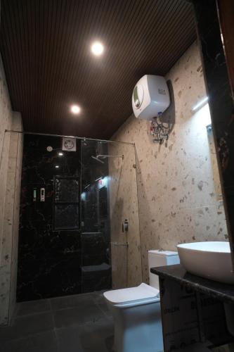 a bathroom with a shower and a toilet at Ramjay Corbet Jungle Resort in Kotdwāra