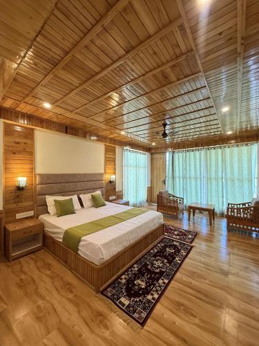 a bedroom with a large bed and a wooden ceiling at Vezara homestay in Kūfrī
