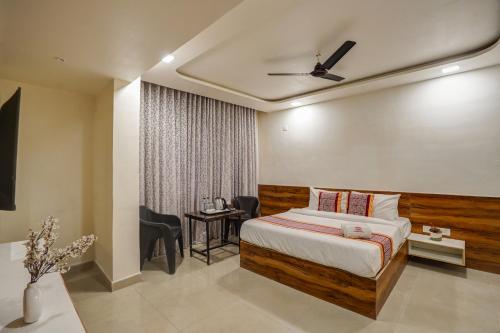 a bedroom with a bed and a table and chairs at Hotel Sayba Inn - Budget Stay! in Pune