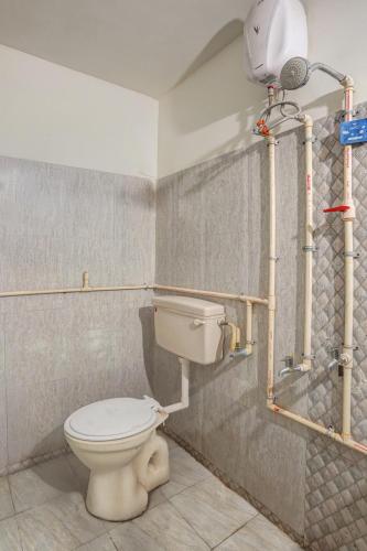 a bathroom with a toilet and a shower at Hotel Sayba Inn - Budget Stay! in Pune