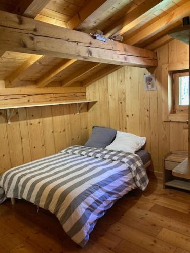 une chambre avec un lit dans une cabane en bois dans l'établissement Maz'Altitude, à La Celle-sous-Gouzon