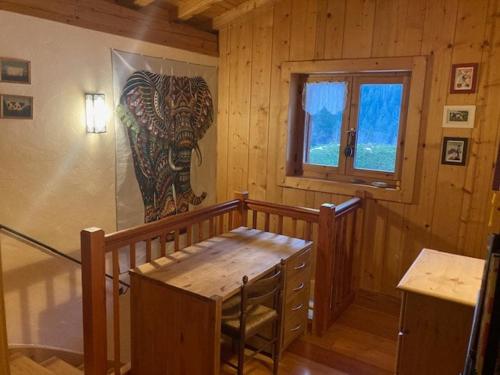 une pièce en bois avec un tableau d'éléphant sur le mur dans l'établissement Maz'Altitude, à La Celle-sous-Gouzon
