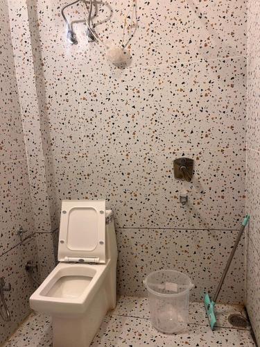 a bathroom with a white toilet in a stall at Hotel Uday Palace in Rishīkesh