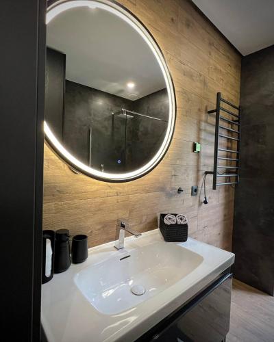 a bathroom with a white sink and a mirror at Paporoti House in Korostov