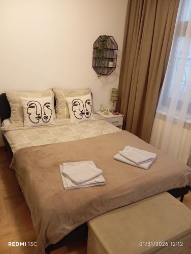 a bedroom with a bed with two towels on it at Apartman Vuk in Obrenovac