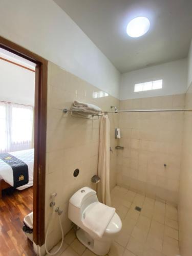 ein Badezimmer mit Toilette und Dusche in der Unterkunft Concordia Hotel Bumi Sangkuriang Bandung in Bandung