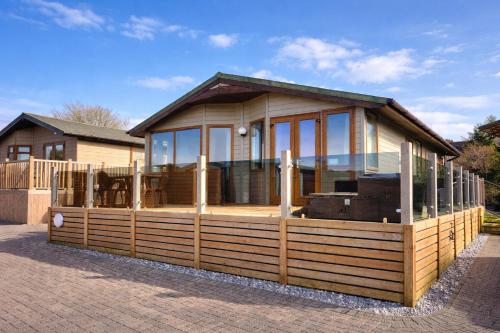 a house with a screened in porch with glass at Beautiful Lodge Retreat - 3 Bedrooms - Sleeps 6 in West Down