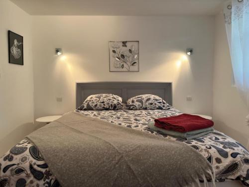 a bed with two pillows on it in a bedroom at Beaurivage, studio privé dans maison d'hôte avec parc in Libourne