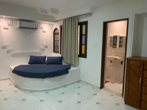 a bedroom with a blue bed and a sink at A passos do paraíso!! in Lauro de Freitas