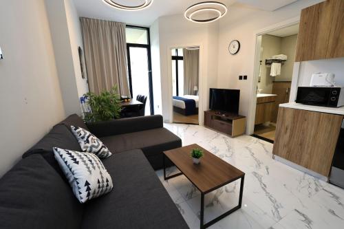 a living room with a couch and a table at 1 Bed Junior near Cleveland and Galleria Mall by Central Stay in Abu Dhabi