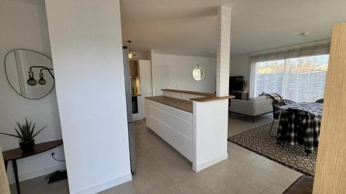 a kitchen with a sink and a living room at La villa caroline in Léon