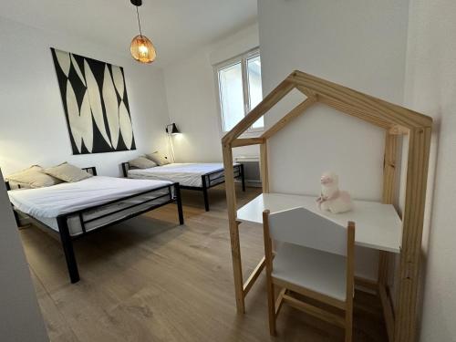 a room with two beds and a chair in it at La villa caroline in Léon