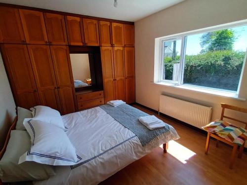 a bedroom with a large bed with a window at Hook Lighthouse Cottage in Ramsgrange