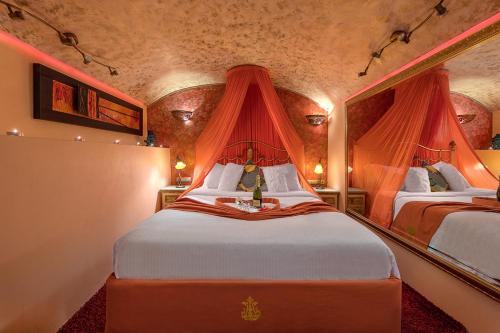 a bedroom with two beds with red curtains at boutique hotel FASHI NIK in Rhodes Town