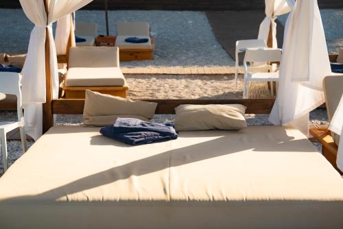 a bed with pillows and umbrellas and chairs at Hotel Morina Palace in Dhërmi