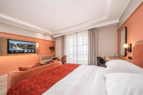 a hotel room with a large bed and a tv at Courtyard Hotel Gqeberha in Port Elizabeth