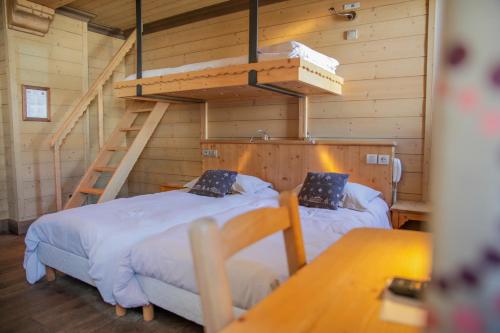 a bedroom with two beds and a ladder at Le Paquis in Tignes