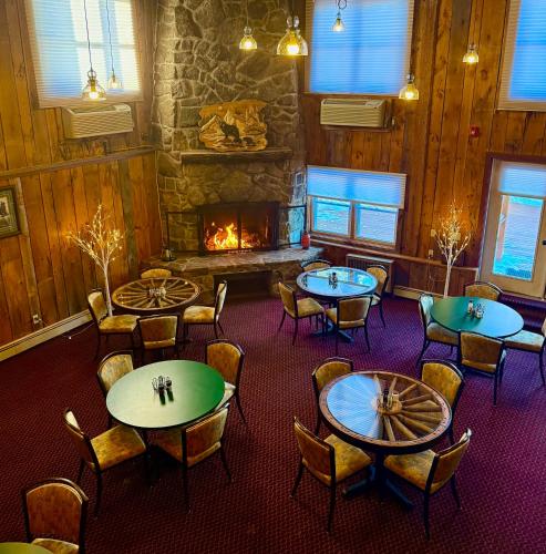 a room with tables and chairs and a fireplace at Merrill Farm Inn in North Conway