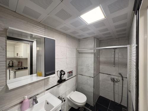 a bathroom with a shower and a toilet and a sink at Saklıkonak Otel in Isparta