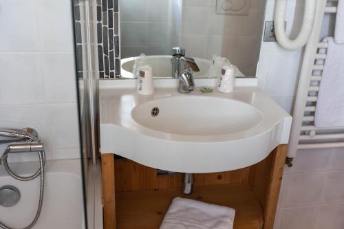 a white sink in a bathroom with a shower at Le Paquis in Tignes