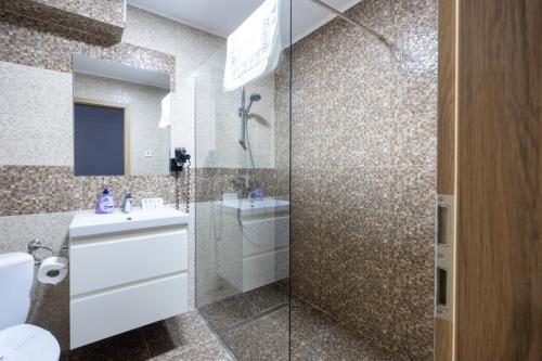 a bathroom with a toilet and a sink and a shower at Pensiunea Rosenau in Râşnov