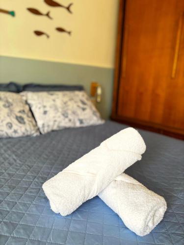 a pair of white towels on a bed at Suíte aMAR in São Pedro da Aldeia
