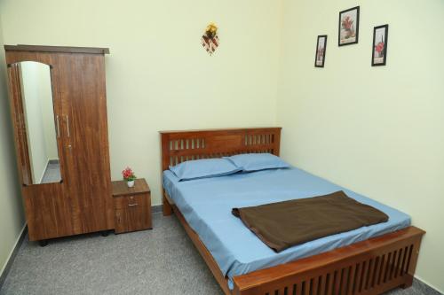 a bedroom with a bed and a dresser and a mirror at serene cottage in Yelagiri