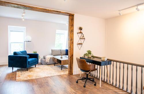 a living room with a blue chair and a desk at Halifax's Most Popular Historic Modern Space in Halifax