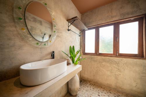 a bathroom with a large white sink and a mirror at Cozy Home Saluang in Ban Lua Ka