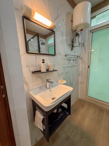 a bathroom with a sink and a mirror at Bel appartement a Yaoundé Bastos in Yaoundé