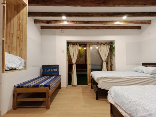 a bedroom with two beds and a window with curtains at Cálido apartamento in Puno