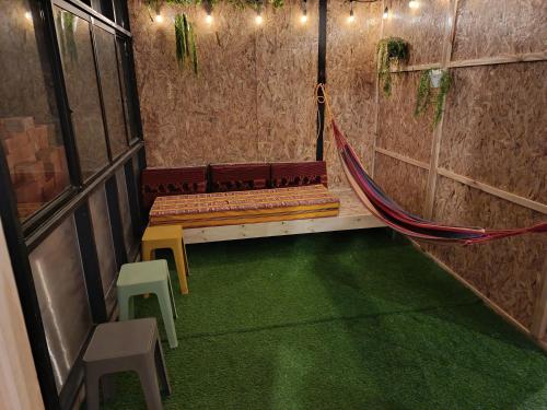 a room with a hammock in a building with green carpet at Cálido apartamento in Puno