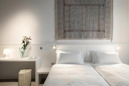 a bedroom with two beds and a table with a vase of flowers at CP Resort in Taverne