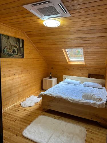 a bedroom with a bed in a wooden wall at Bujtina Alpine Vanat in Bele