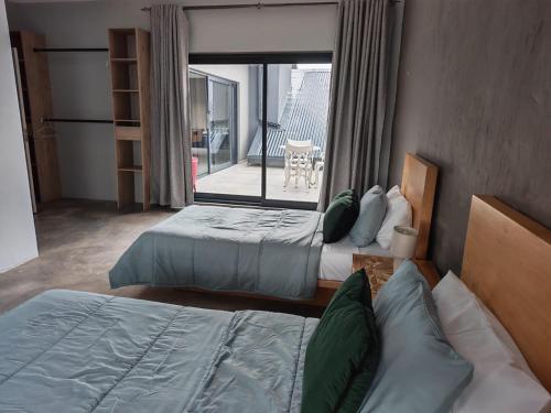 a hotel room with two beds and a balcony at Tee Off House - Parys Golf and Country Estate in Parys