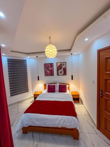 a bedroom with a large bed and a chandelier at Bel appartement a Yaoundé Bastos in Yaoundé