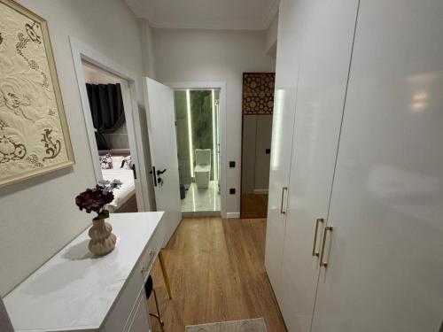 a kitchen with white cabinets and a vase of flowers at Maiden Tower Prestige in Baku