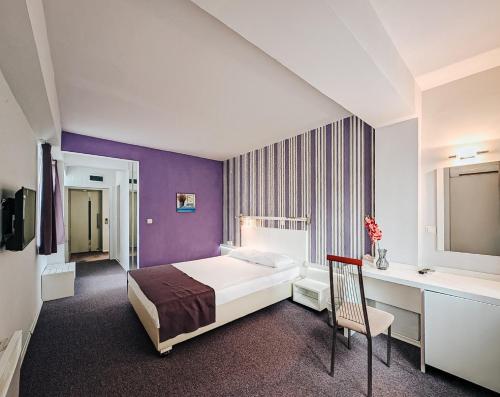 a hotel room with a bed and a desk at Violet Stay in Skopje