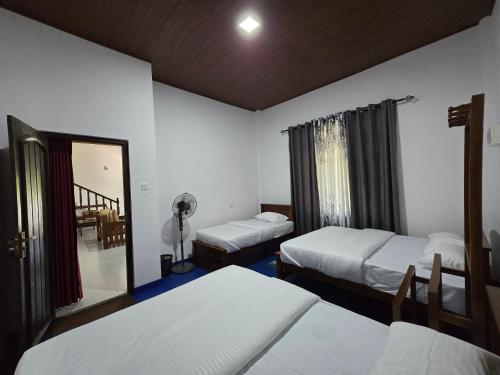 a bedroom with two beds and a mirror at Meadow Villa - Ella in Ella