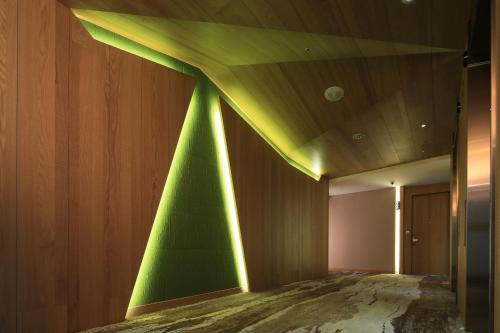 a room with a green wall with lights on it at South Urban Hotel in Chiayi City