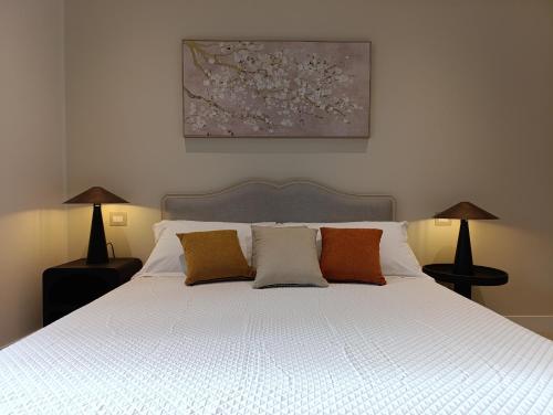 a bedroom with a white bed with three pillows at Le Finestre su Villa d'Este in Tivoli