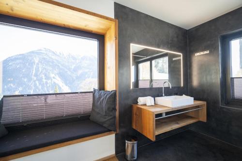a bathroom with a sink and a large window at Chasa Vital in Sent