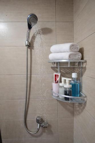 a shower with a shower head in a bathroom at Soft Reset Room by YOMAIN in Kemirimuka Tiga
