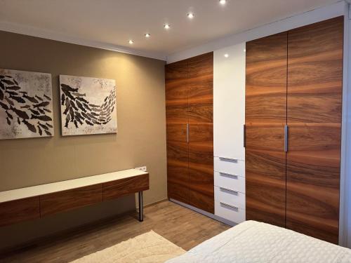 a bedroom with a bed and a wooden closet at Appartement Muller-Mayer in Weissensee