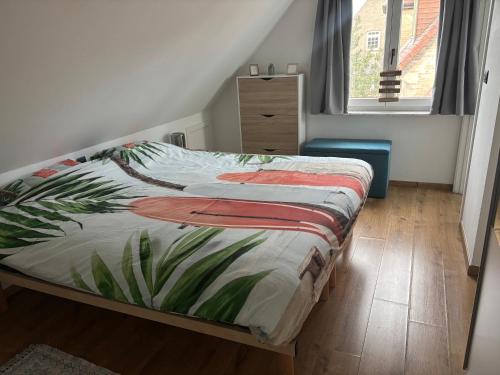 a bedroom with a bed with a tropical blanket on it at Vacanzamare in Wenduine
