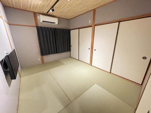 an empty room with white cabinets and a television at Guest house TOMORI - Vacation STAY 11064v in Shingū